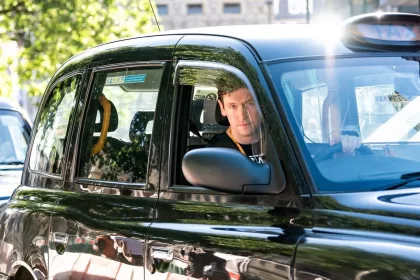taxi driver driving a black cab