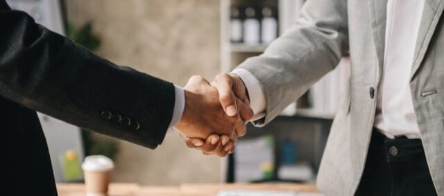 Two confident business man shaking hands during a meeting in the office, success, dealing, greeting and partner