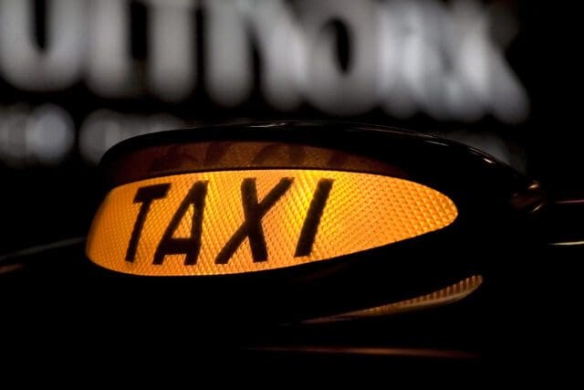 close up of an orange taxi sign lit up at night