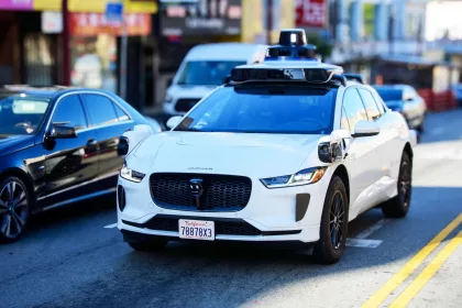 Front side view of Waymo Jaguar driverless car on urban street.