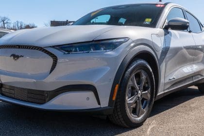 Electric Ford Mustang sedan at a dealership on a sunny day