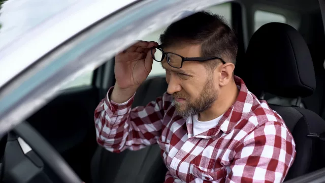 Tired driver taking eyeglasses off