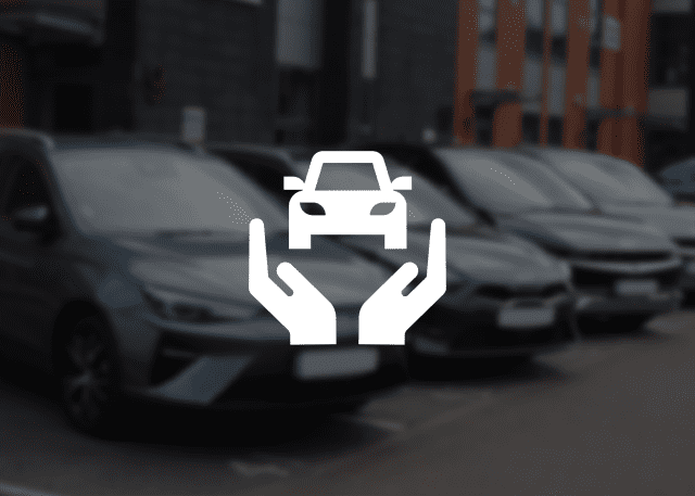 A line of cars parked outside of Patons Insurance's Liverpool Office. The image is slightly blurred and overlayed with an icon that shows two hands holding a car, representing insurance coverage.