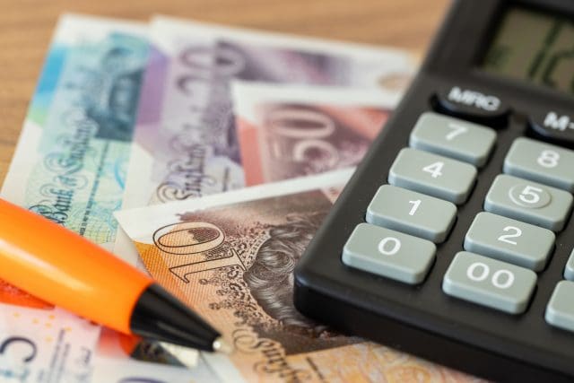 British pound notes and calculator on a desk