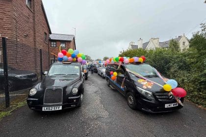 Two black cabs decorated with balloons for the Liverpool Taxi Outing 2025.