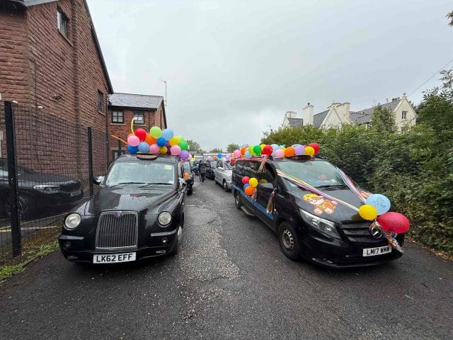 Two black cabs decorated with balloons for the Liverpool Taxi Outing 2025.
