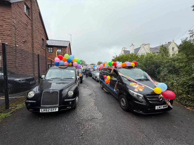 Two black cabs decorated with balloons for the Liverpool Taxi Outing 2025.