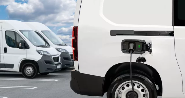 Fleet of electric delivery vans at an electric vehicles charging station.