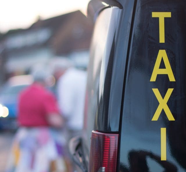 Taxi Rank with black mini cab and yellow sign