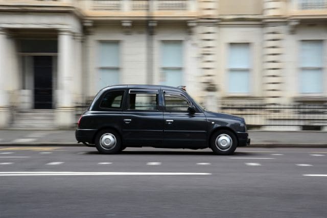 Panning shot of a black taxi