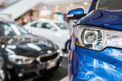 New cars in dealer showroom interior background. Guide on motor trade insurance
