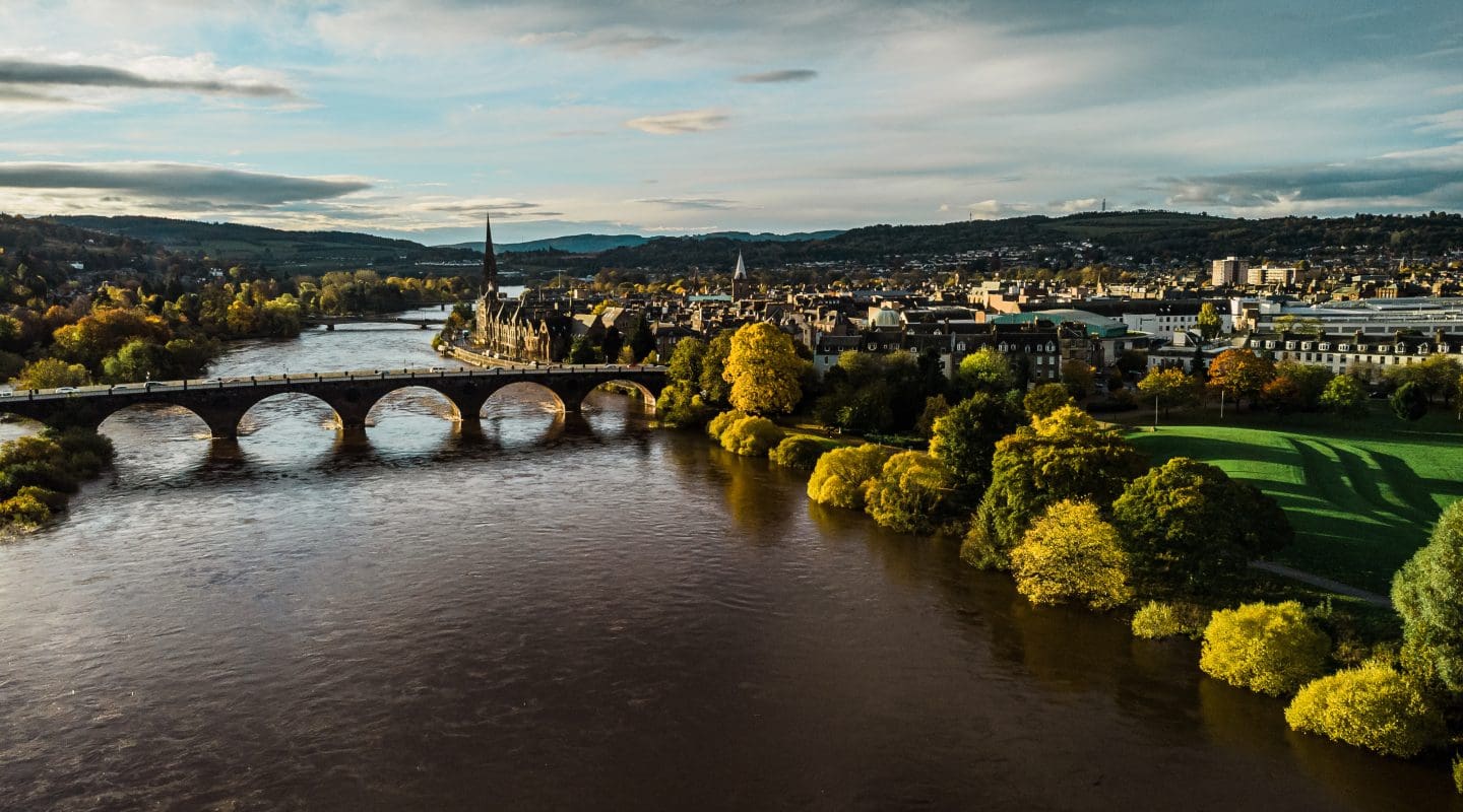 Perth, Scotland, and the River Tay in autumn colours. Taken by drone you can see the Perth Bridges and Concert Hall.