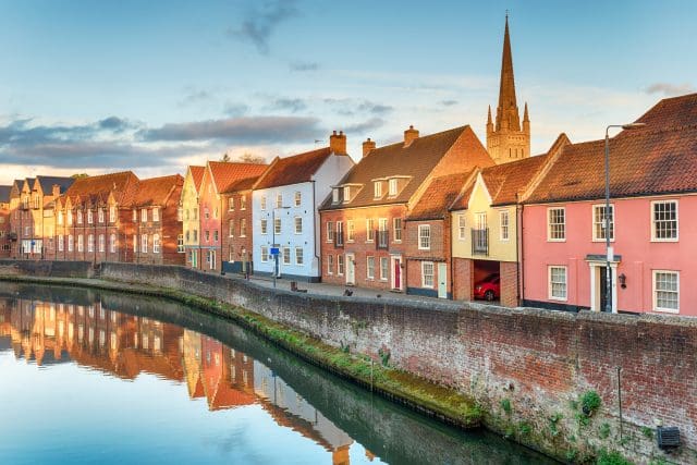 Pretty town houses overlooking the river Yare at Norwich in Norfolk with the cathedral spire in the background