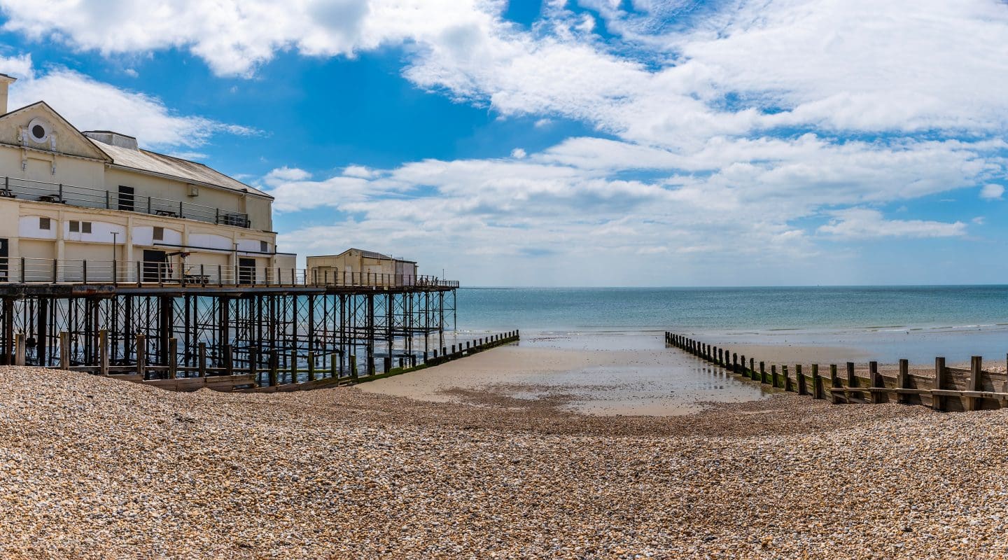 A view past the pier and breakwater out to sea at Bognor Regis, Sussex in summertime