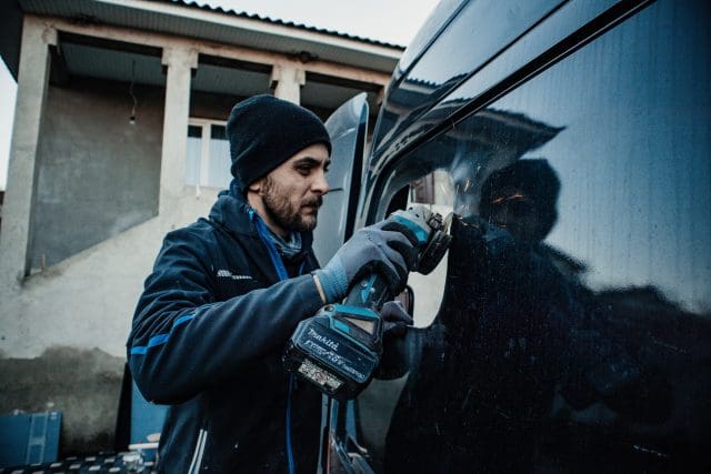 Tradesman working on a vehicle using powertools