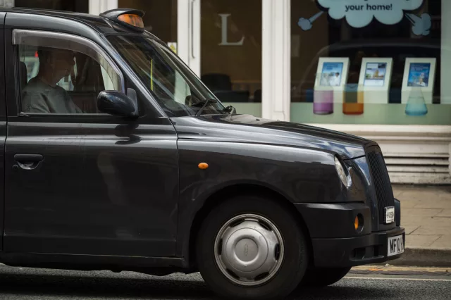 side shot of black cab taxi on a city road