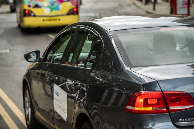 private hire vehicle (uber) driving down a busy city road