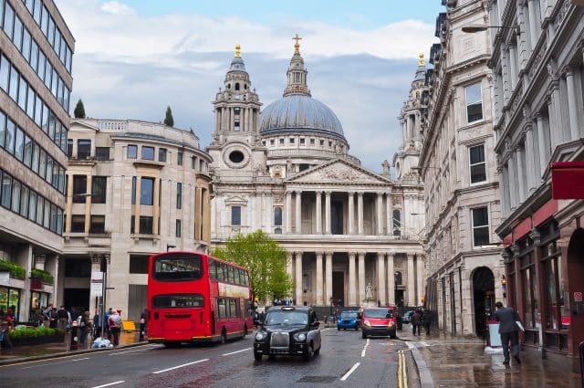 Black cab taxi driving down London road with St. Paul's Cathedral visible in the background