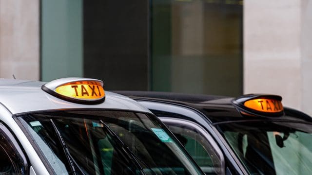 A british black taxi cab sign with defocused background