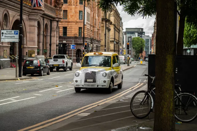 Public hire taxi driving from Deansgate in Manchester
