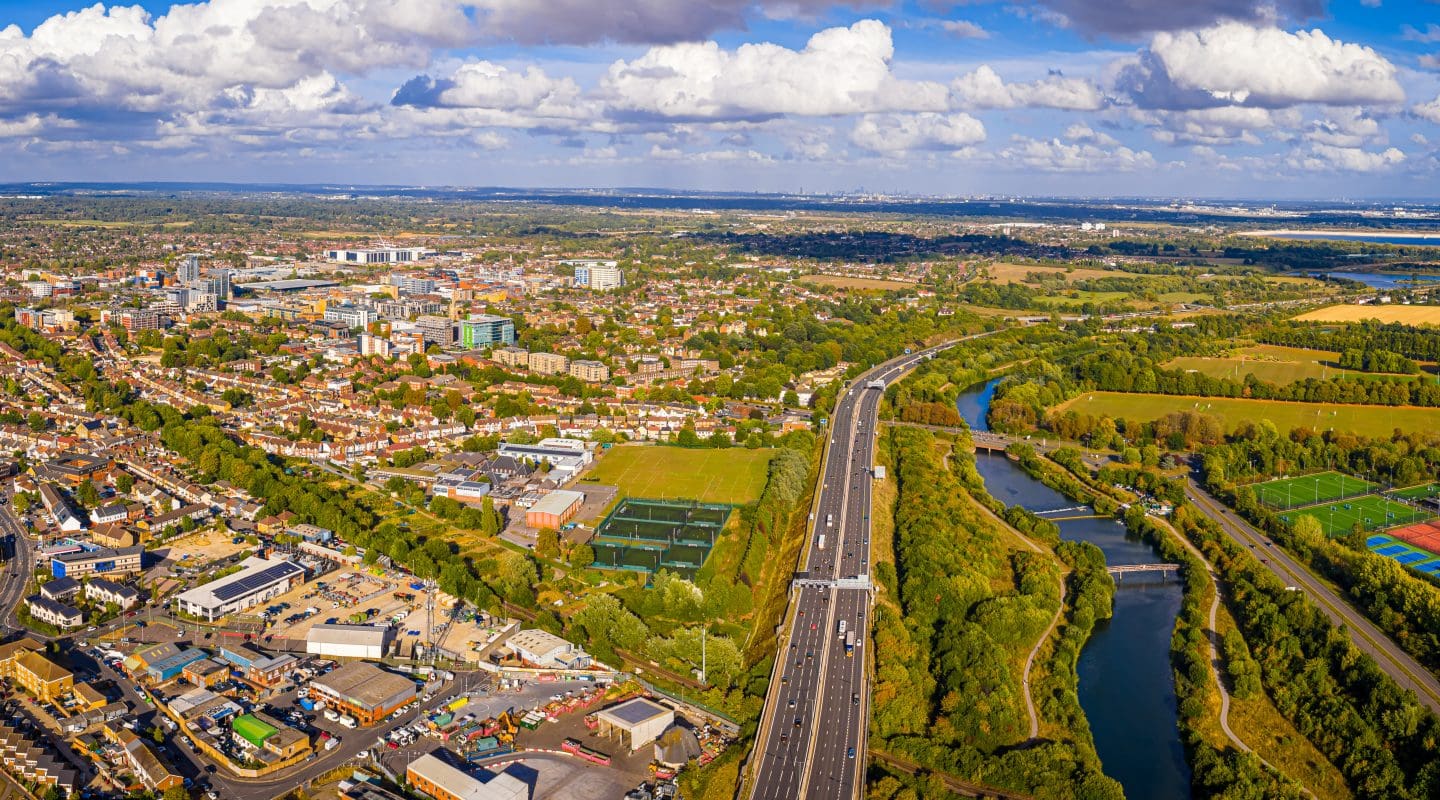 Wide-angle drone image of Slough, England showing urban development, train tracks, business districts, and parks