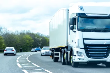 A large HGV vehicle traveling along one of the main road routes of the United Kingdom, on a summer's day. Taking goods to and from their suppliers and customers.