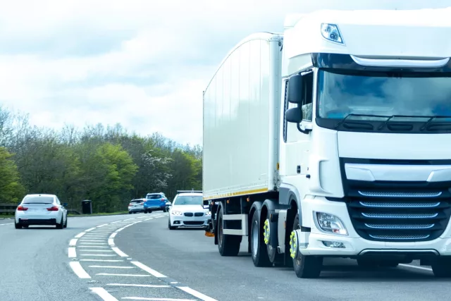 A large HGV vehicle traveling along one of the main road routes of the United Kingdom, on a summer's day. Taking goods to and from their suppliers and customers.