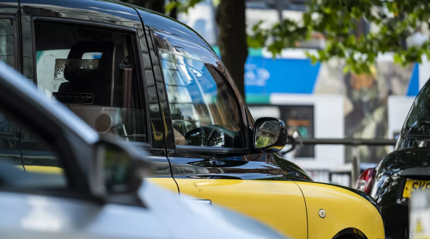 Public hire and private hire taxi waiting in traffic