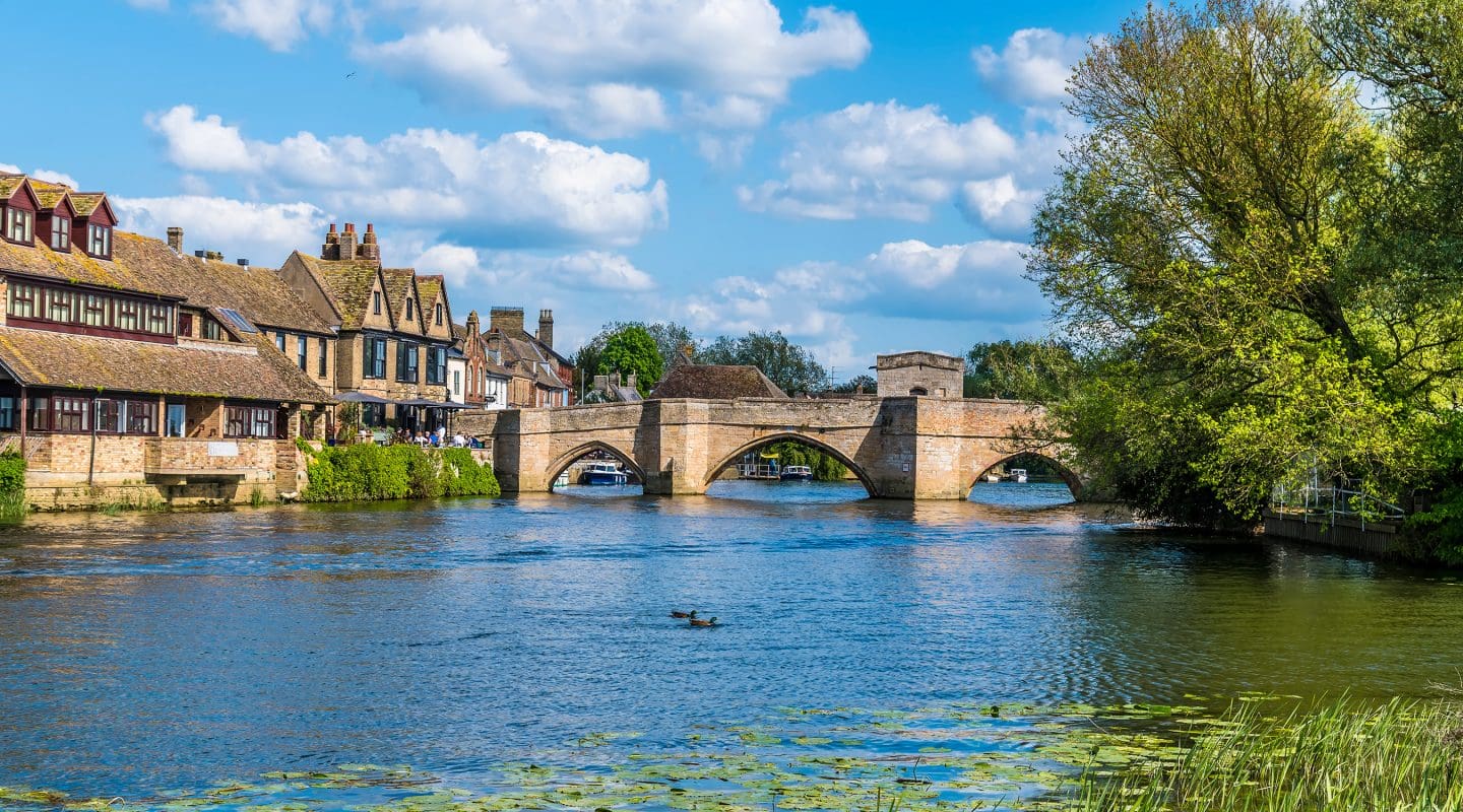 A view along the River Great Ouse towards the footbridge and quayside at St Ives in summertime