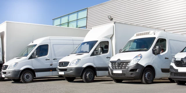 fleet of commercial vehicles including lorries, trucks and vans parked in a bay