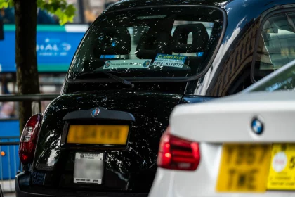 black cab taxi and PHV waiting side by side at traffic light