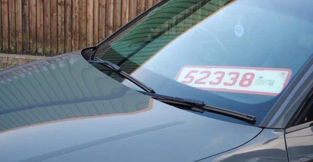 Trade plate pictured in front window of car