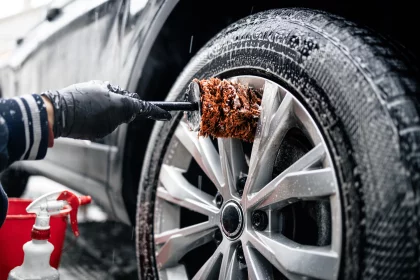 Close up view of car wheel being washed with the brush and soap.