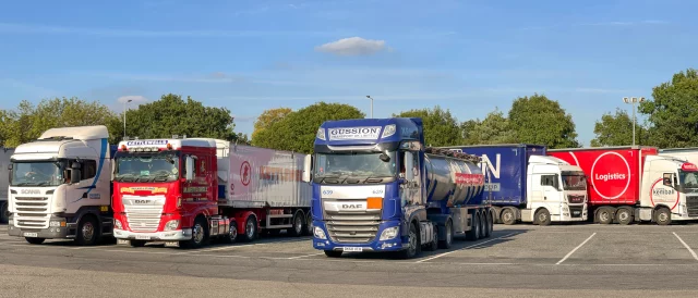 Articulated hgvs parked in a row in a motorway service station and rest area