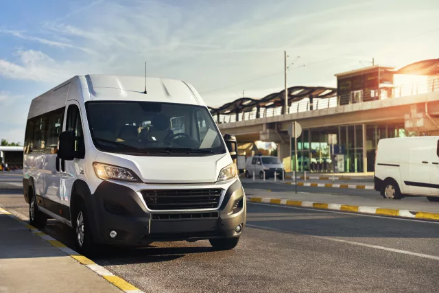 Minibus airport shuttle on background monorail station