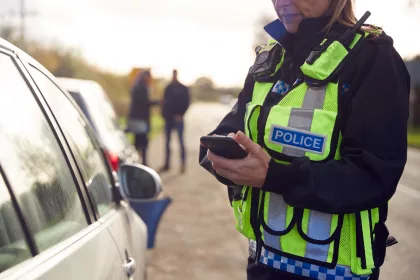 Female Traffic Police Officer Recording Details Of uninsured vehicle