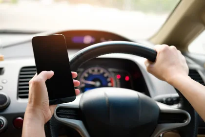 driver holding mobile phone while driving