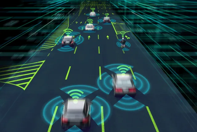 A digital illustration of vehicles driving on a multi-lane highway at night. Cars and a motorcycle are shown with glowing radar circles and Wi‑Fi icons above them, while neon lane markings and data-grid graphics suggest vehicle-to-vehicle communication and smart transportation technology.