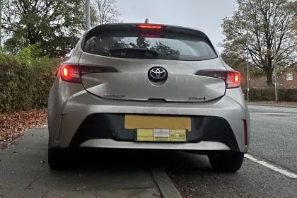 rear of private hire vehicle parked on the side of a quiet residential street