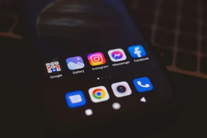 A smartphone displaying popular social media apps in a dimly lit environment.