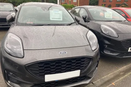 Used Ford cars for sale parked outside in the rain