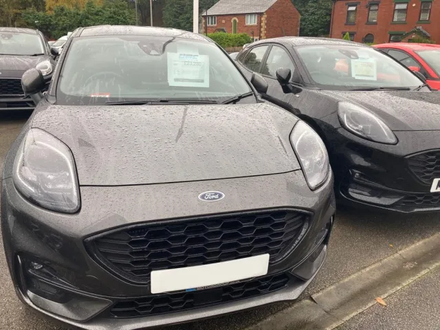 Used Ford cars for sale parked outside in the rain