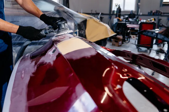 motor trader using grinding machine for body of car.