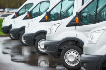 fleet of white commercial vans parked in a row