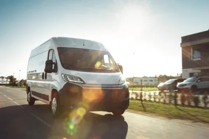 New Delivery Van Driving Through the suburban Town Area on a sunny day.
