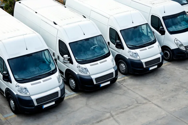 overhead shot of a white delivery van fleet parked in a line