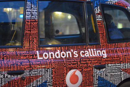 Close up of a side of a London Black cab with the words London's Calling written down the side.